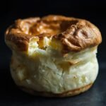 A close-up of a deflated soufflé, its golden crust cracked