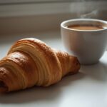 A close-up of a once-flaky croissant, now slightly flattened and