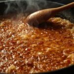 A close-up of a paella pan with a golden, crispy