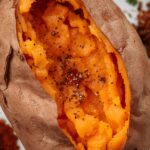 A close-up of a perfectly baked sweet potato, split open