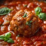 A close-up of a sizzling meatball in a rustic cast-iron