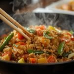 A close-up of a sizzling plate of fried rice with
