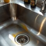 A close-up of a stainless steel sink with a rainbow
