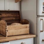 A rustic wooden bread box on a kitchen counter, slightly