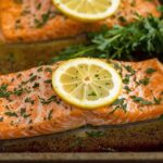 A sizzling sheet pan of roasted salmon fillets, fresh out