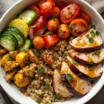 A vibrant, colorful grain bowl with quinoa, roasted vegetables, grilled